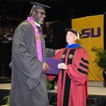 Legenda NBA Shaquille O'Neal tersenyum mengenakan toga saat wisuda S2 di Louisiana State University