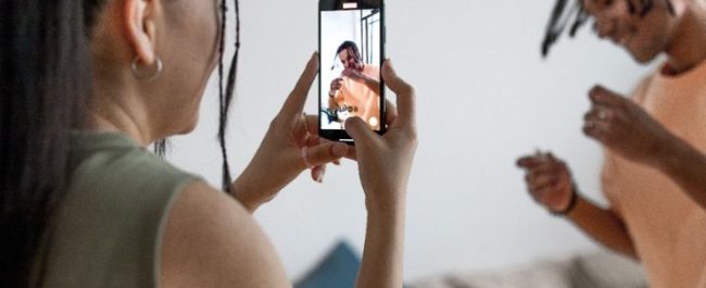 Ilustrasi seseorang sedang merekam dan mengunggah video menggunakan ponsel pintar